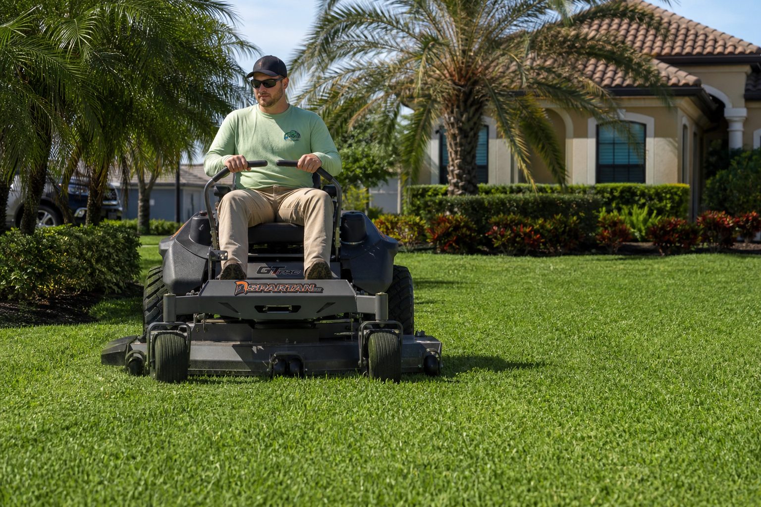 Professional ride-on mower cutting a residential lawn